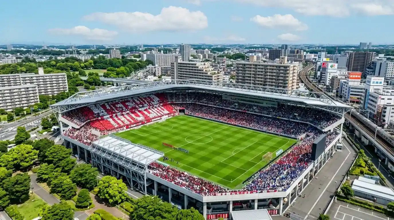 Vista aérea de un estadio de J1 League con el campo de fútbol profesional japonés iluminado para un partido nocturno